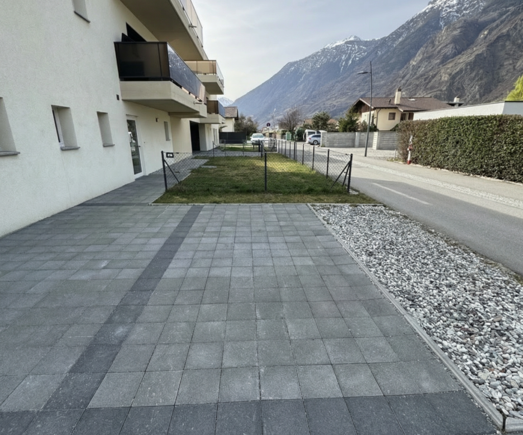 Außenbereich vor moderner Wohnanlage mit Bergblick