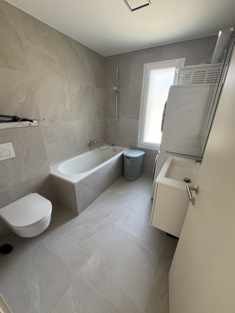 Modernes Badezimmer mit Badewanne und Hauswirtschaftsbereich